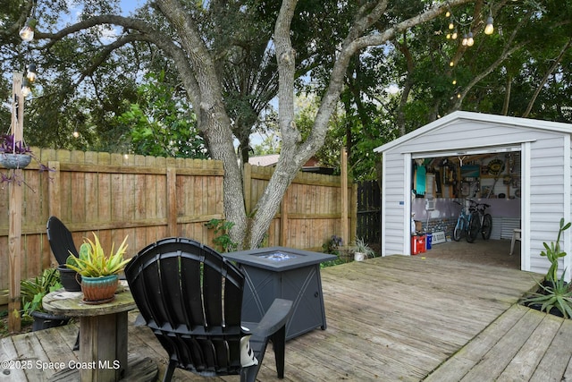 wooden deck with a storage unit and a fire pit