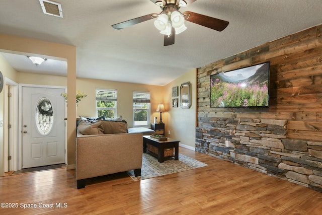 living room with hardwood / wood-style flooring, vaulted ceiling, and a textured ceiling