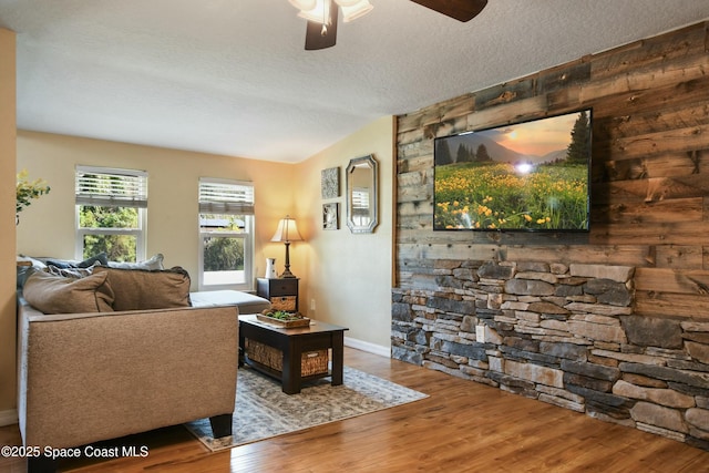 living room featuring ceiling fan, hardwood / wood-style floors, and a textured ceiling