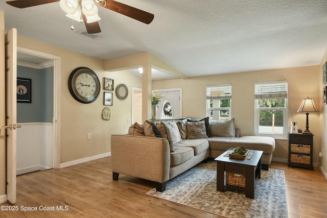 living room with a textured ceiling and light wood-type flooring