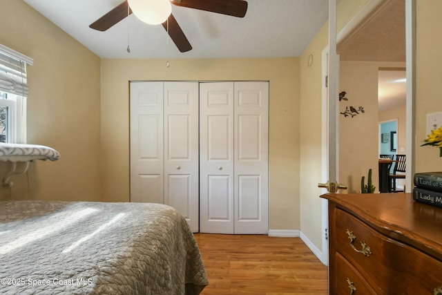 bedroom featuring light wood-type flooring, ceiling fan, and a closet