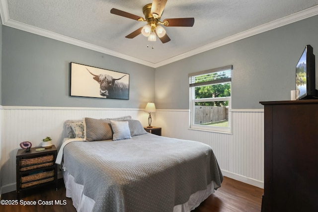 bedroom featuring crown molding, dark hardwood / wood-style flooring, a textured ceiling, and ceiling fan