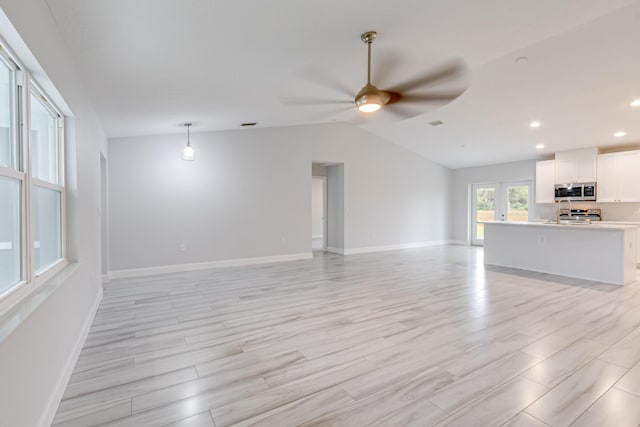 unfurnished living room featuring ceiling fan, light hardwood / wood-style floors, and lofted ceiling