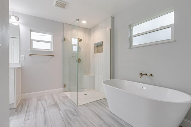 bathroom with plenty of natural light, vanity, and independent shower and bath