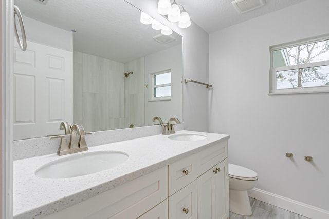 bathroom featuring a textured ceiling, toilet, and vanity