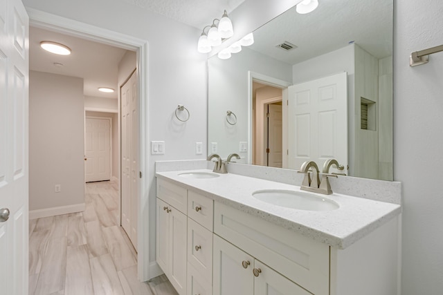 bathroom with a textured ceiling and vanity