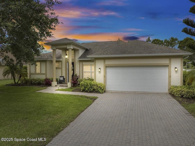 prairie-style home with a garage and a yard