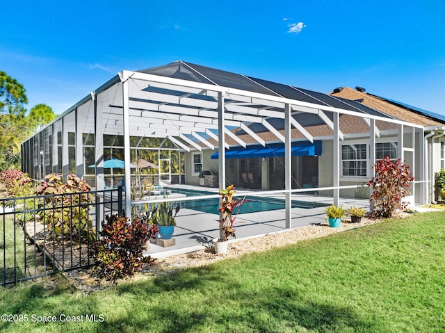 rear view of property featuring a patio area, a lawn, and glass enclosure