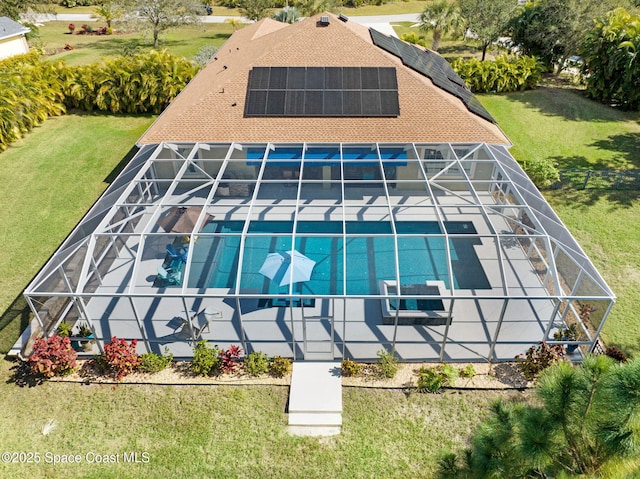 exterior space featuring a patio, a yard, and glass enclosure