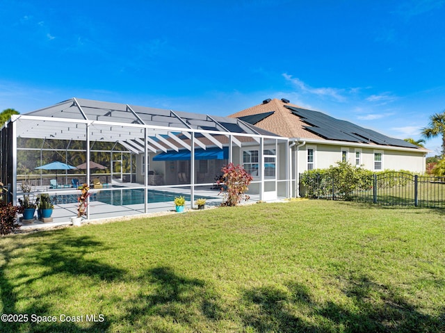 rear view of property with a fenced in pool, a lanai, and a lawn