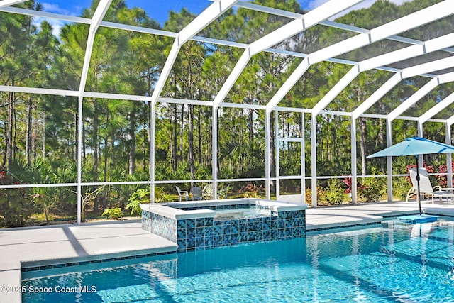 view of pool with an in ground hot tub, a patio, and glass enclosure