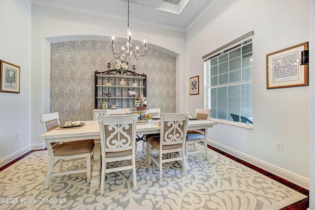 dining room with an inviting chandelier, ornamental molding, and hardwood / wood-style floors