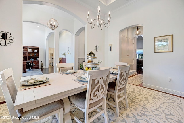 dining area with a notable chandelier, ornamental molding, and light wood-type flooring