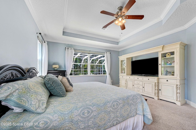 carpeted bedroom featuring a raised ceiling, crown molding, ceiling fan, and a textured ceiling