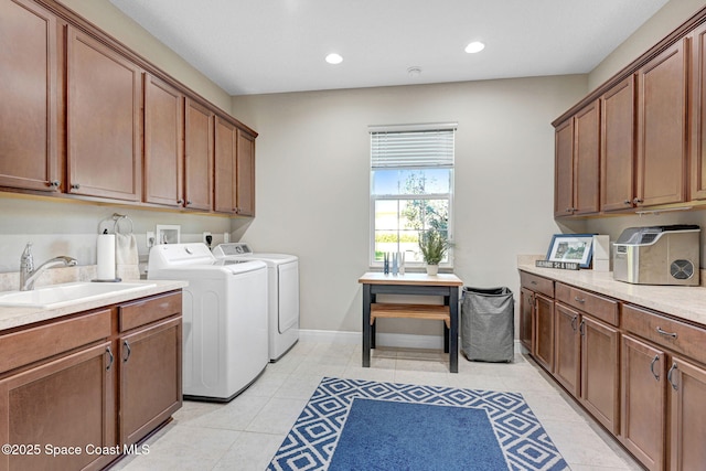 laundry room with cabinets, washer and clothes dryer, sink, and light tile patterned floors