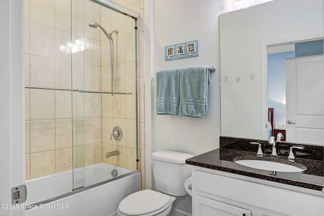 full bathroom with enclosed tub / shower combo, vanity, and toilet