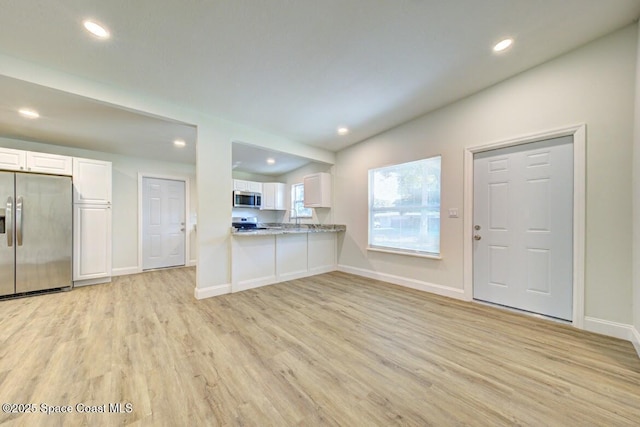 kitchen featuring white cabinetry, light hardwood / wood-style flooring, kitchen peninsula, and appliances with stainless steel finishes