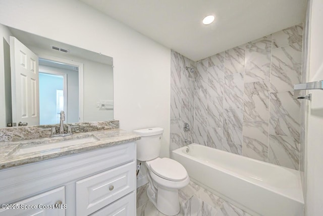 full bathroom with tiled shower / bath, vanity, and toilet