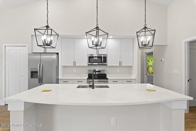 kitchen with pendant lighting, an island with sink, and appliances with stainless steel finishes