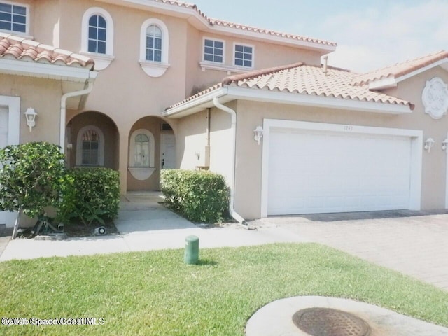 mediterranean / spanish home with a garage