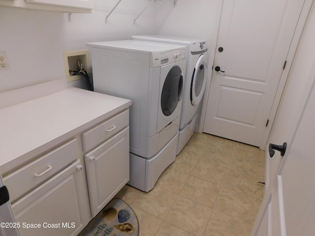 laundry area with cabinets, washer and dryer, and light tile patterned floors