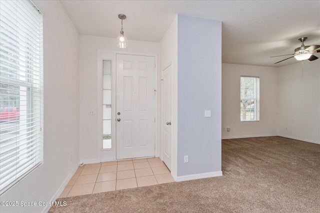 foyer entrance featuring ceiling fan and light colored carpet