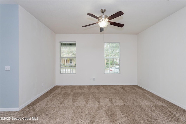 carpeted spare room featuring ceiling fan