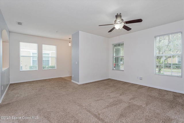 spare room featuring a healthy amount of sunlight, carpet flooring, and ceiling fan