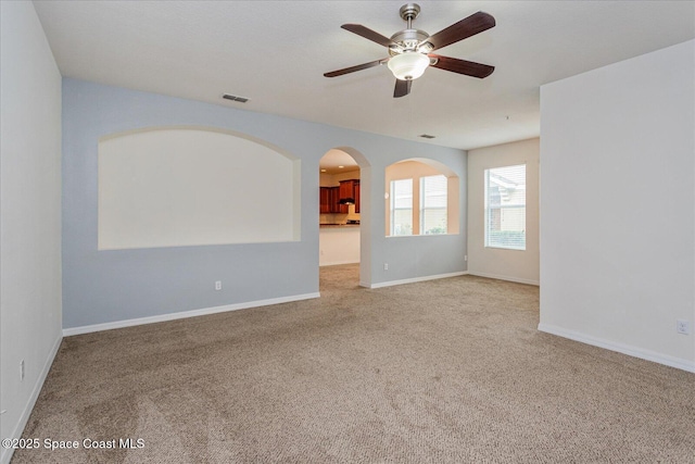 carpeted spare room featuring ceiling fan