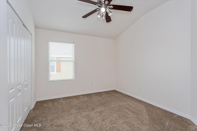 carpeted spare room featuring ceiling fan and lofted ceiling