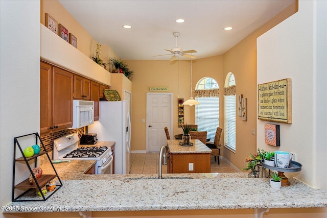 kitchen featuring kitchen peninsula, white appliances, and sink