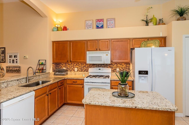 kitchen with sink, white appliances, light tile patterned floors, and light stone countertops