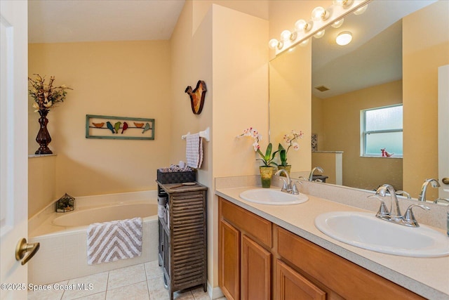 bathroom with vanity, a relaxing tiled tub, and tile patterned flooring