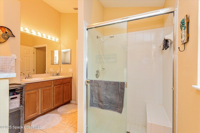 bathroom with a shower with shower door, vanity, and tile patterned flooring