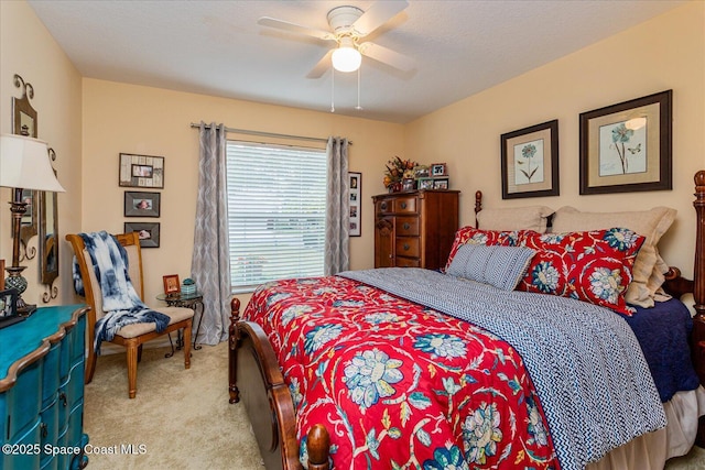 bedroom with ceiling fan, light colored carpet, and a textured ceiling