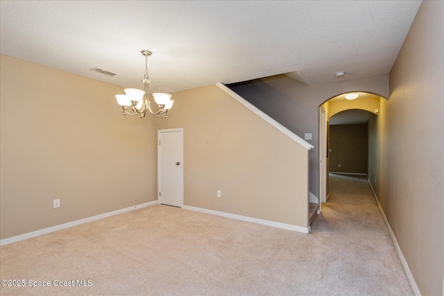 unfurnished room with a chandelier and light colored carpet