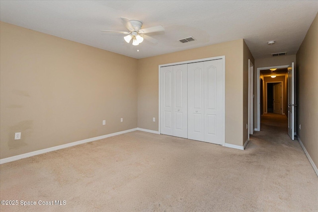 unfurnished bedroom featuring light carpet, a closet, and ceiling fan