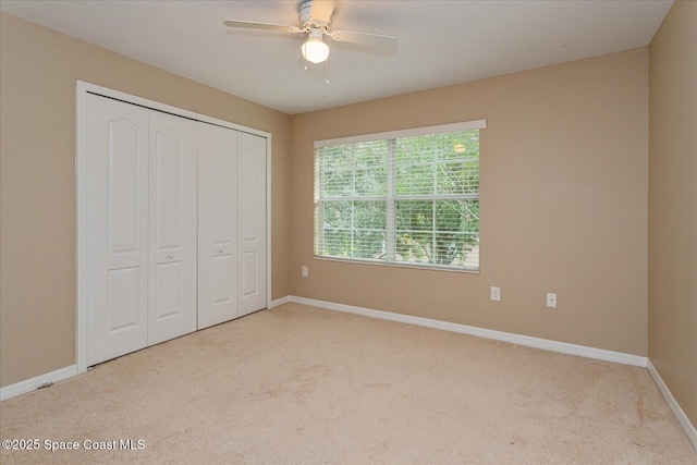 unfurnished bedroom featuring a closet, ceiling fan, and light carpet