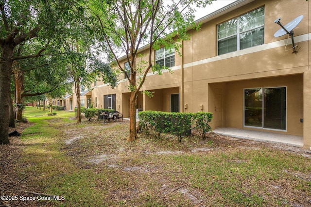 back of property featuring a patio area and a yard