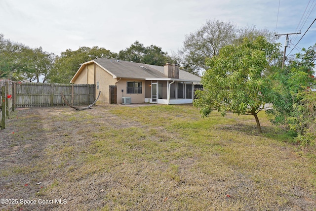 back of house featuring a sunroom and a lawn