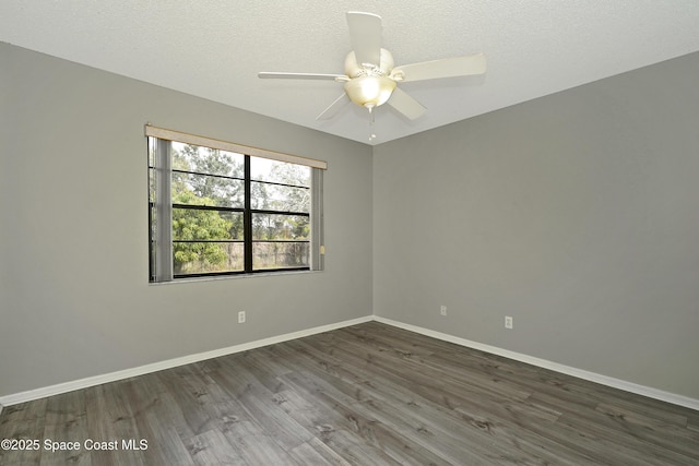 empty room featuring ceiling fan, dark hardwood / wood-style floors, and a textured ceiling