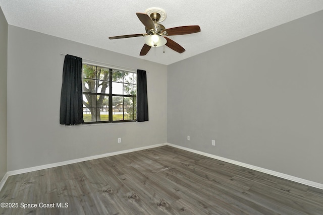 empty room with ceiling fan, dark hardwood / wood-style floors, and a textured ceiling