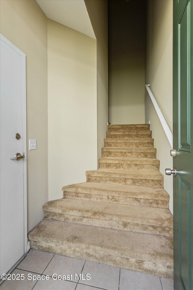 stairway with tile patterned floors