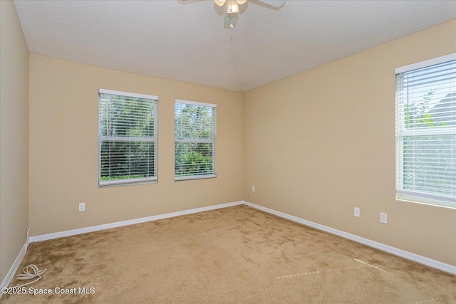 carpeted empty room featuring ceiling fan