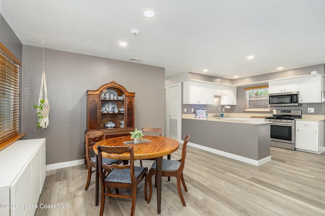 dining room with sink, radiator heating unit, and light hardwood / wood-style floors