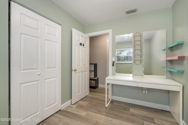 bathroom featuring hardwood / wood-style floors and a textured ceiling