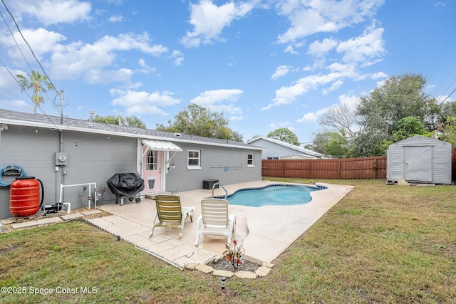 view of pool with area for grilling, a patio, a yard, and a shed