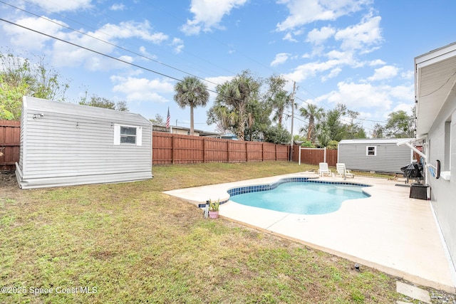 view of swimming pool with a patio, a lawn, and a storage unit