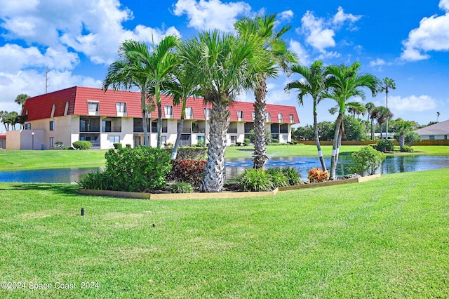 view of home's community with a lawn and a water view