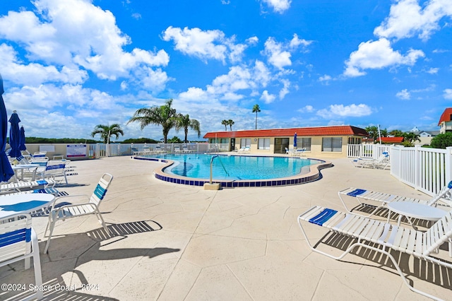 community pool featuring a patio and fence